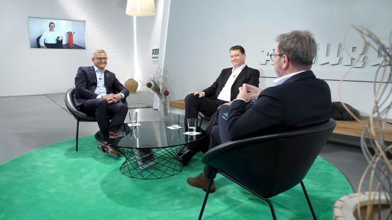 Top-class round of experts at arburgXvision: Peter Barlog (screen), managing partner of Barlog Plastics GmbH, Arburg managing director Gerhard Böhm (l.) and development engineer Dr.-Ing. Philipp Kloke (centre) discussed plastics as a driver of innovation with moderator Guido Marschall.